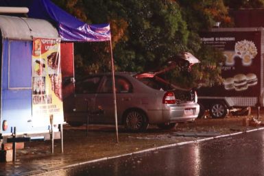 A damaged car is seen near Brazil's Supreme Court in Brasilia after two blasts occurred, killing a man who tried to force his way into the court