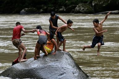 Embera Indigenous children swim in the Atrato river in Colombia's Choco department