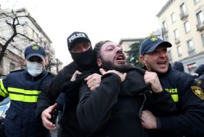 Georgian police officers detain a demonstrator Tuesday during new protests against last month's parliamentary vote