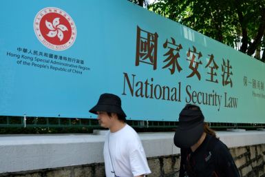 Pedestrians walk past a government public notice banner for the National Security Law in Hong Kong on July 15, 2020