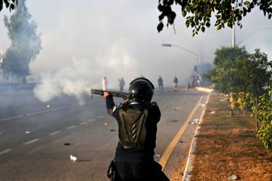 A policeman fires rubber bullets to disperse supporters of the Pakistan Tehreek-e-Insaf party in Islamabad