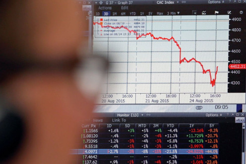 A sales manager looks at a screen which shows the decline in value of French CAC 40 stocks at Allianz Global Investors in Paris, France, August 24, 2015.  