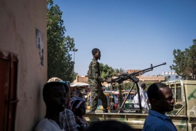 A Sudanese army soldier mans a machine gun on top of a military pickup truck outside a hospital in Omdurman