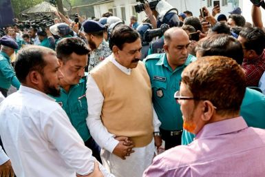 Thirteen Bangladeshi former top government officials appeared in court on Monday under heavy guard to face charges of inciting massacres
