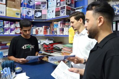 Young men in Misrata discuss leaflets handed out by election campaigners